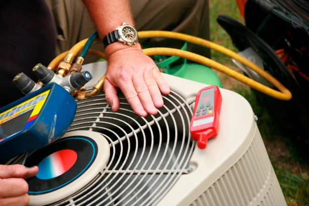 Technician checking an outdoor condenser with HVAC service gauges