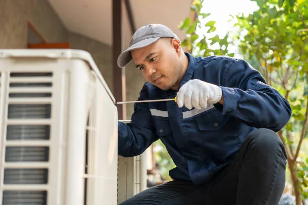 HVAC technician inspecting a residential outdoor air conditioning unit